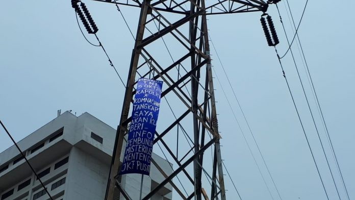 Panjat Tower SUTET, Seorang Pemuda Bawa Spanduk “Tangkap Saya”