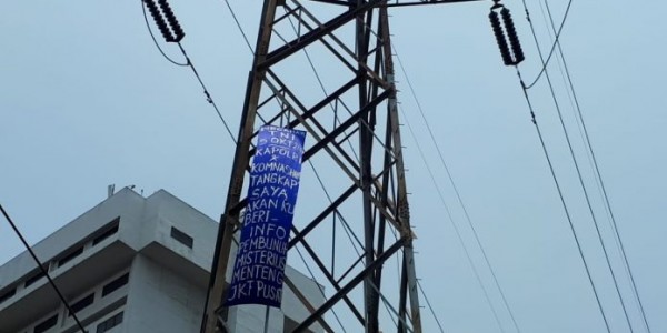 Panjat Tower SUTET, Seorang Pemuda Bawa Spanduk “Tangkap Saya”