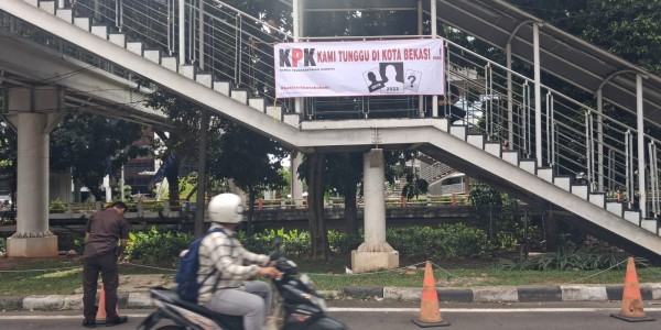 Emaskot Pasang Spanduk Kami Tunggu KPK di Kota Bekasi depan Gedung Merah Putih KPK Jakarta